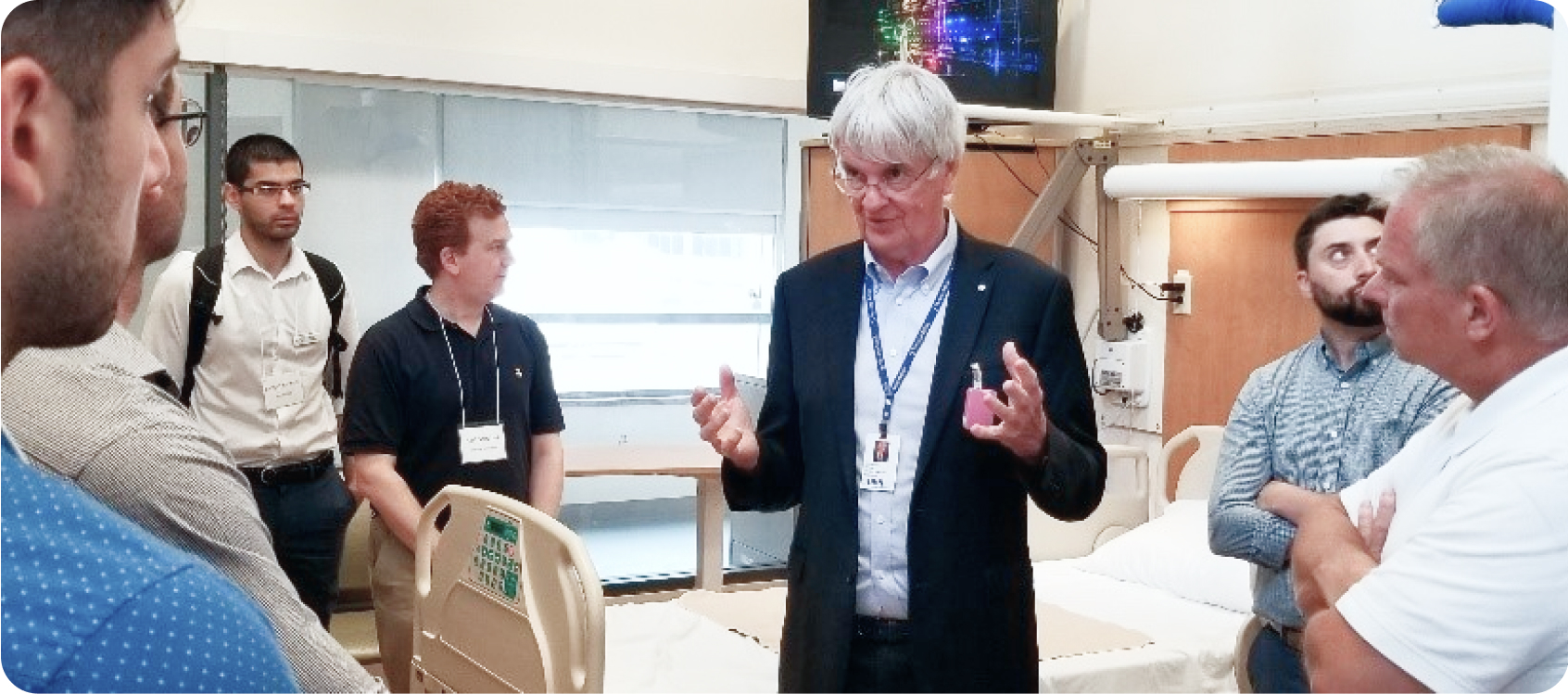 Dr. Geoff Fernie talking to a group of diverse people about his hospital room simulator