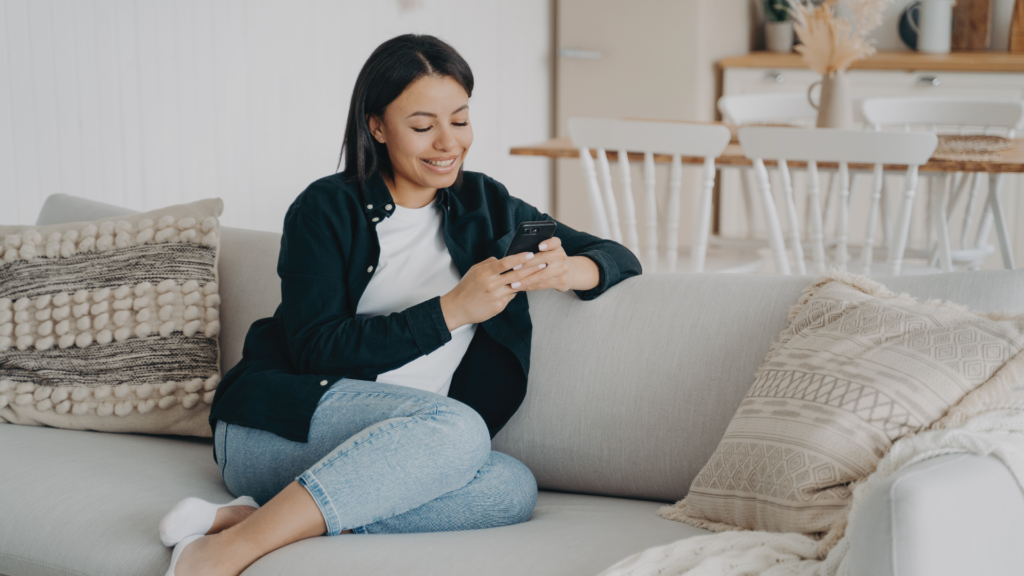 Woman sitting on couch and looking at phone